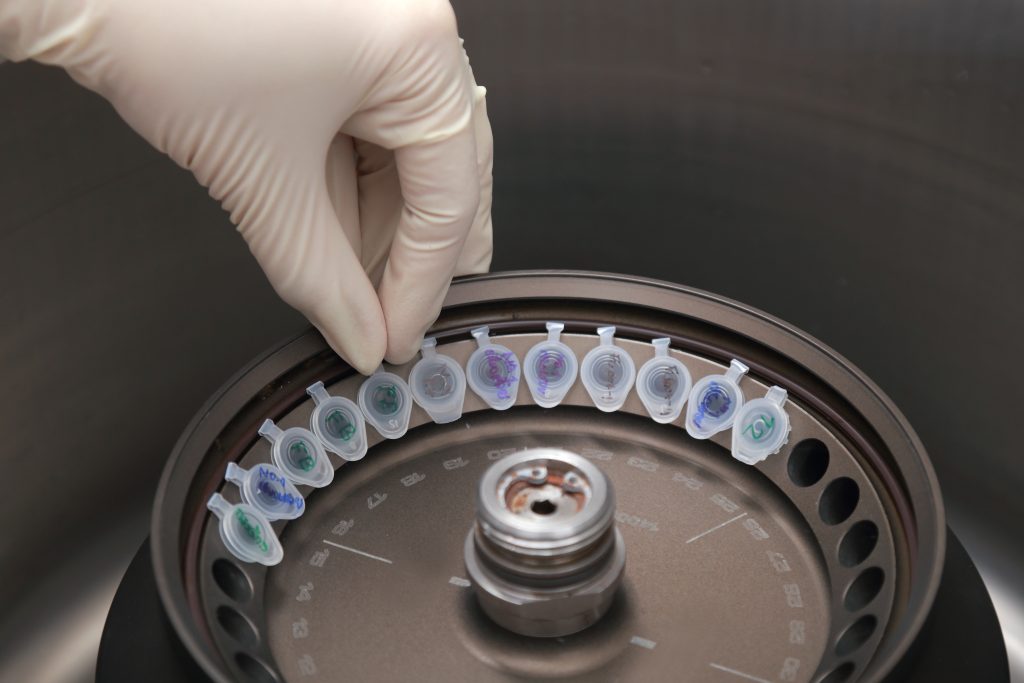 Scientist loading a sample to centrifuge