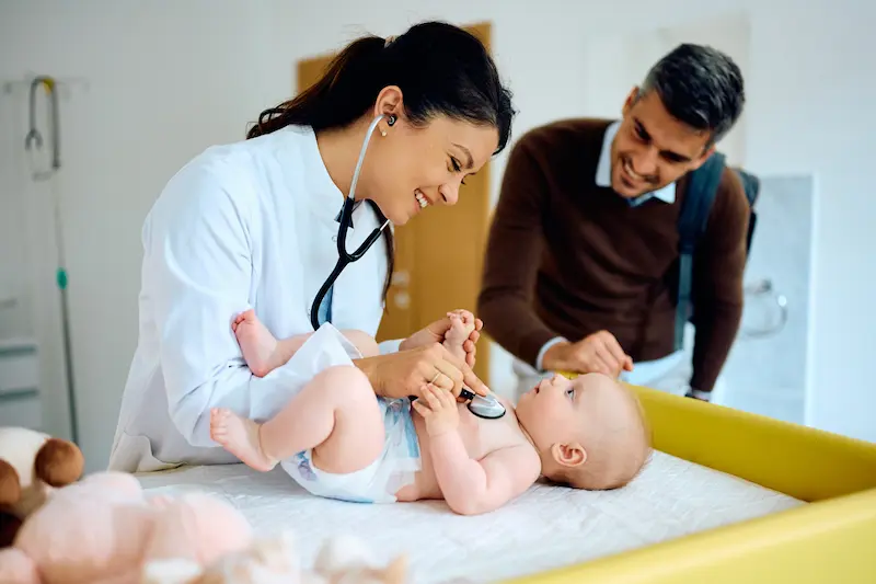 Doctor examining baby at pediatric clinic