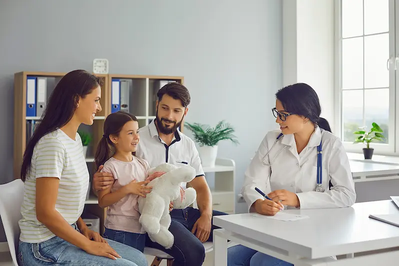 Happy child with her family at pediatric check-up