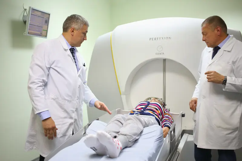 Two doctors prepares the patient for the procedure on the Gamma Knife